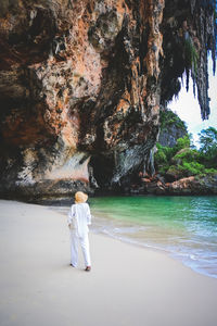 Rear view of woman standing at beach