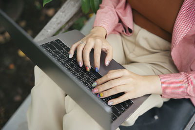 Midsection of woman using laptop at home