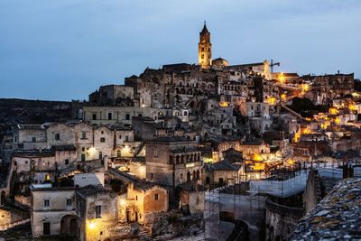 Illuminated buildings in city against sky