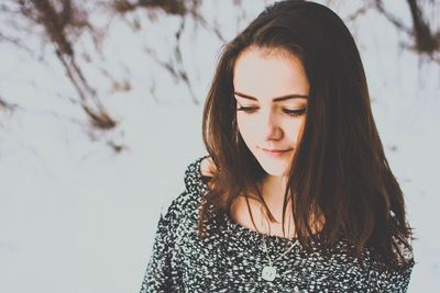 Close-up portrait of young woman against the sky