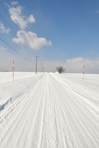 Snow covered field against sky