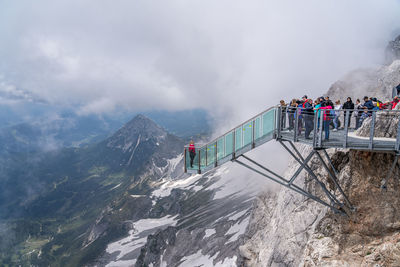 People on snowcapped mountain against sky