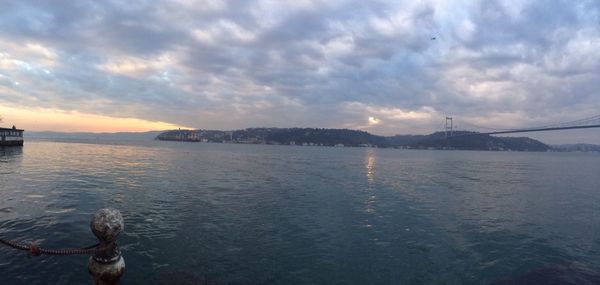 Scenic view of sea against cloudy sky at sunset