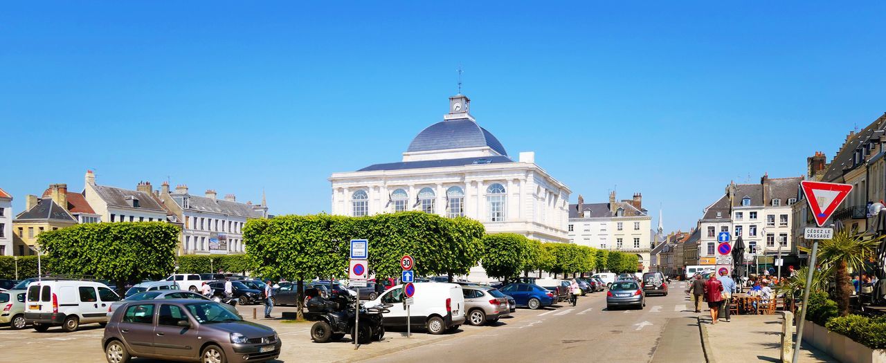 building exterior, architecture, built structure, car, motor vehicle, mode of transportation, transportation, land vehicle, sky, city, building, clear sky, nature, street, incidental people, road, plant, tree, day, copy space, outdoors, government