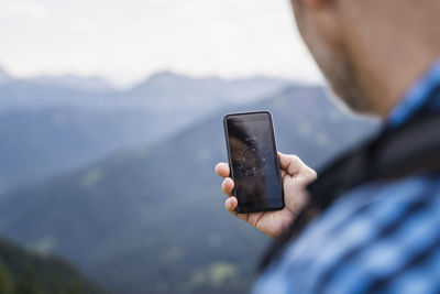 Male hiker searching direction through mobile phone