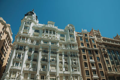 Facade with flamboyant decoration on old buildings full of windows, in a sunny day at madrid, spain.