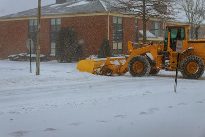 Snow covered field by building during winter