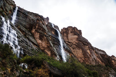 Low angle view of waterfall against sky