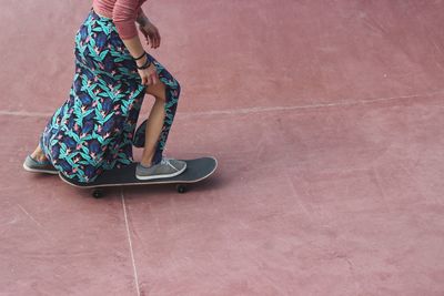 Low section of woman skateboarding at park