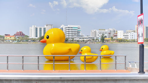 Yellow toys on railing by river