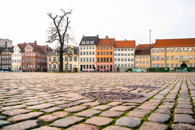 Surface level of footpath by buildings against sky