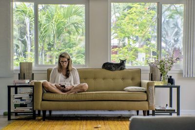 Woman sitting on sofa at home