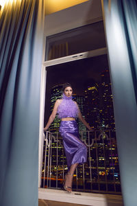 Rear view of young woman standing against wall