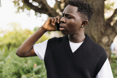 Young african man talking on phone shocked, stressed, unsatisfied