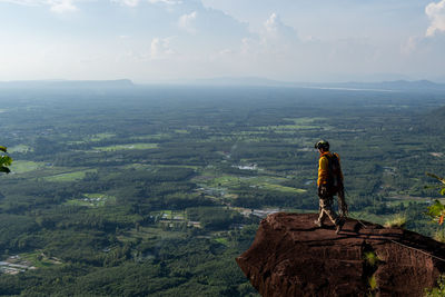 Man standing on rock looking at mountain landscape