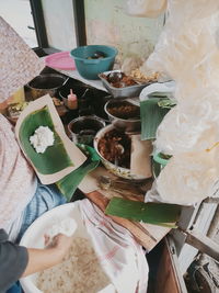 High angle view of woman holding food on table