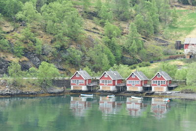 Houses by lake against trees and mountains