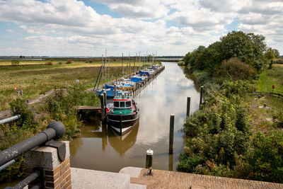 Boats moored in river against sky