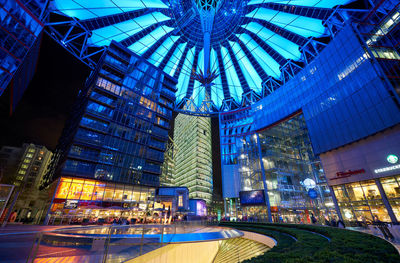 Low angle view of illuminated shopping mall at night