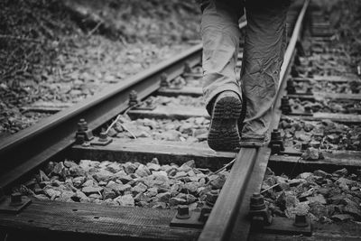 Low section of man walking on railroad track