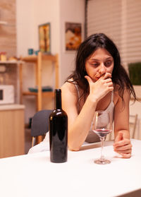 Portrait of young woman sitting on table