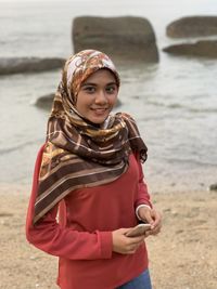 Portrait of woman standing at beach