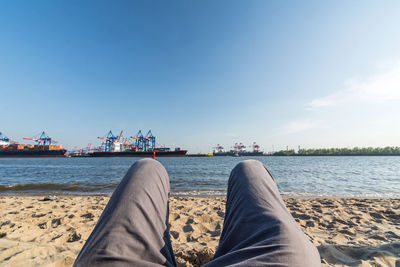 Midsection of man relaxing at beach