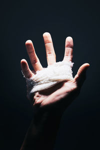 Close-up of human hand against black background