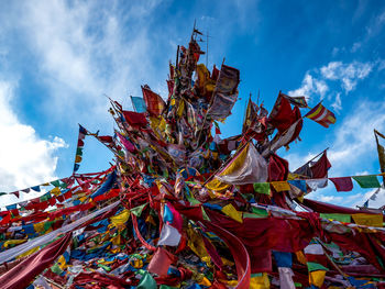 Low angle view of multi colored flags against sky