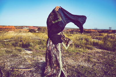 Side view of woman on field against clear sky