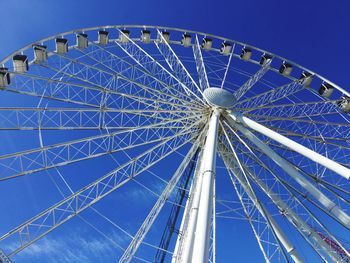 Low angle view of ferris wheel against blue sky