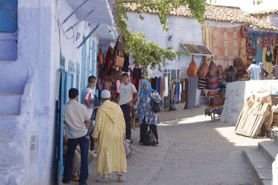 Rear view of people walking on street in city