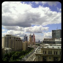 Skyscrapers in city against cloudy sky