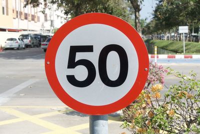 Close-up of speed limit sign by plants