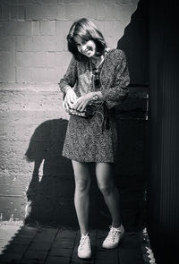 Modest smiling young woman in short dress on a sunny day in the shade