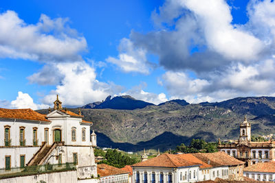 Buildings in city against cloudy sky