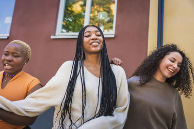 Smiling multiracial young female friends hanging out together on weekend