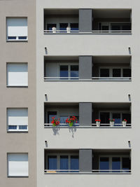 Facade of the modern apartment building, one balcony with flowers