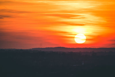 Scenic view of silhouette landscape against orange sky