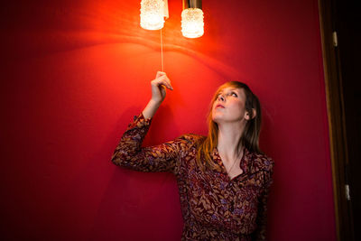 Full length of woman standing against wall