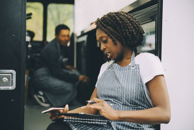 Female owner using digital tablet against food truck