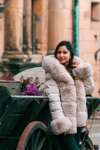 Portrait of young woman sitting on street