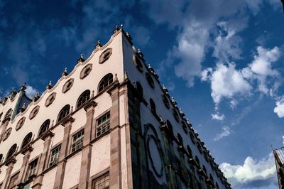 Low angle view of building against cloudy sky