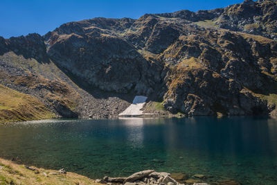 Scenic view of lake by mountain against sky