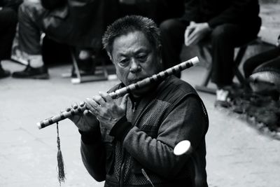 Mature street musician playing flute