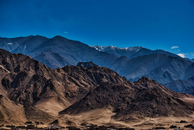 Scenic view of mountains against blue sky