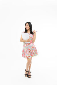Portrait of young woman standing against white background