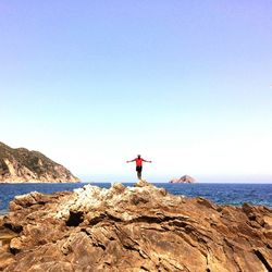 Man standing by sea on rock