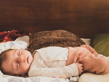 Close-up of baby girl sleeping on bed at home