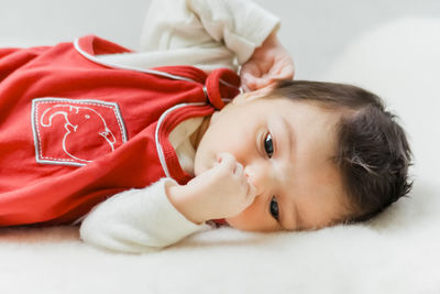 Portrait of cute baby girl lying on bed